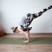 a woman doing a handstand on a yoga mat